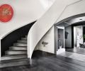 The original drywall staircase that had a wooden railing became all drywall; stair treads are engineered wood from Castle Bespoke Flooring; LED strip lighting lights black staircase wall. Peter Gronquist painting hovers like the moon.