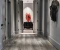 By unifying the hallway finishes that included wood and painted surfaces with a single gray paint, Boyer’s red steel mesh artwork becomes center stage.