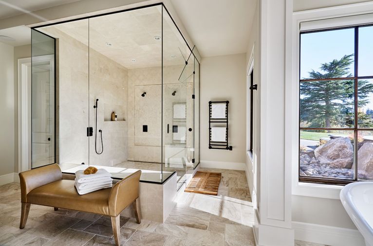 A spacious steam shower and European towel warmer counter floor-to-ceiling cabinets at vanity.