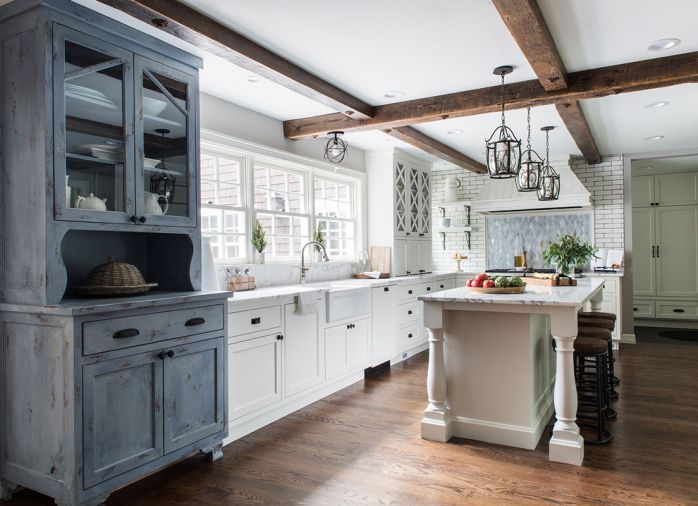 To underscore the home’s established farmhouse style, Taryn designed a rustic hutch to bring a warmer, more traditional feel into the kitchen. Countertops and backsplash are Calacatta Vettogli marble sourced from Intrepid Marble & Granite. “Throwing in a lot of texture was important,” says Taryn. “In the kitchen alone, you have this really cool Ann Sacks white brick behind the range, the distressed wood hood, the hutch, and the backsplash, which is a beautiful glass mosaic.”