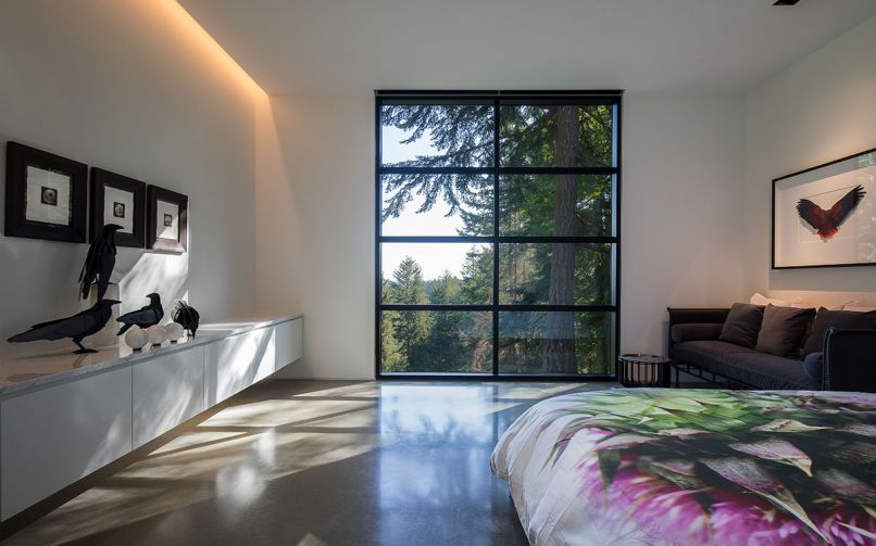 The master bedroom suite features softer cove lighting for a restful feel. Art, including the bedspread, is displayed prominently.