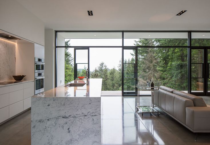 In the kitchen, the island is fully wrapped with with statuary marble, a material chosen for its luster and texture as well as its ability to combine the two primary colors in the home, white and gray.