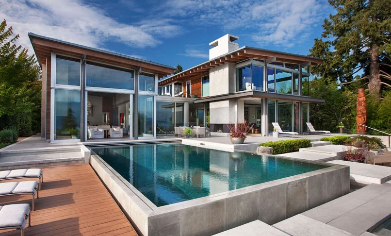 Exposed beams inside and out team with concrete chimney and fireplaces. Poured concrete exterior forms for the stairs, pool and koi pond by GCW.