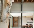 A giant indigenous art mask graces the great room, residing over structural exposed blackened steel and wood beams that look toward the dining room and entry hallway.