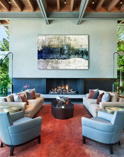 The Great Room steel frame sofas are a GCW custom design with Holly Hunt suede base and outdoor fabric cushions. Holly Hunt Jockey Chairs and leather team with Robert Kuo coffee and drum tables. The Driscoll Robbins rug grounds the room with a pop of red. Its 16' cast-in-place concrete fireplace has blackened metal fireplace and cantilevered hearth.