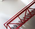 The red steel staircase was an early design touchstone. Red veneer facings on cabinet link to red in other parts of the house.