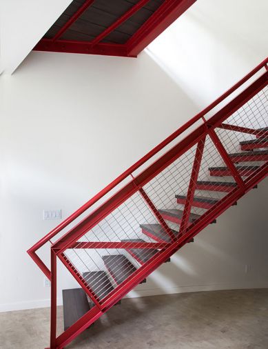 The red steel staircase was an early design touchstone. Red veneer facings on cabinet link to red in other parts of the house.