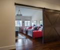 Custom barn door introduces grandchildren’s twin beds.