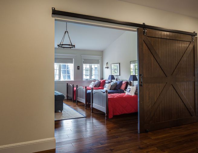 Custom barn door introduces grandchildren’s twin beds.