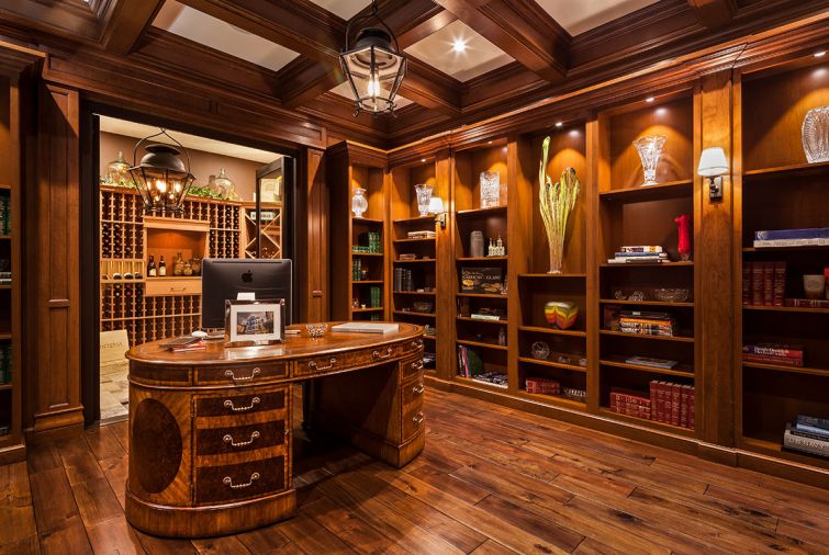 Cherry wainscot paneled built-in, walnut/burl partners desk lead to glass wine cellar doors.