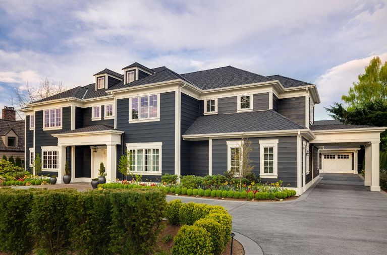 Koch’s symmetrical architectural design features 10' bevel cedar siding. Porte cochere draws eye to detached garage with guest suite.