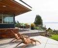 An extra-large overhang, complete with inset heaters, creates a sheltered area to the side of the house for shoulder-season dining and recreation. A custom Ipe cabinet makes space for the homeowners to store outdoor essentials close to the action. The concrete patio is blissfully maintenance-free.