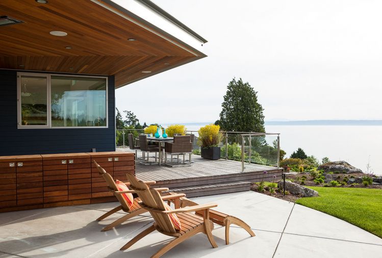An extra-large overhang, complete with inset heaters, creates a sheltered area to the side of the house for shoulder-season dining and recreation. A custom Ipe cabinet makes space for the homeowners to store outdoor essentials close to the action. The concrete patio is blissfully maintenance-free.