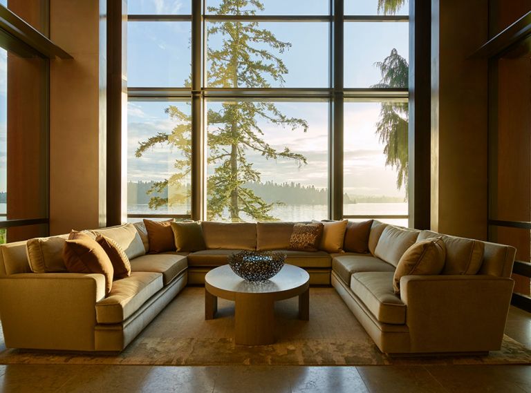 Hunziker’s U-shaped Coraggio mohair sofa nestles before stately Fleetwood windows facing lake on Lapchi rug.