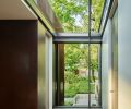 Baba designed the first-floor landing window to overlook entry and sloped property then lit it above from skylight. Cor-Ten steel column left adds rustic texture; Lapchi rug.