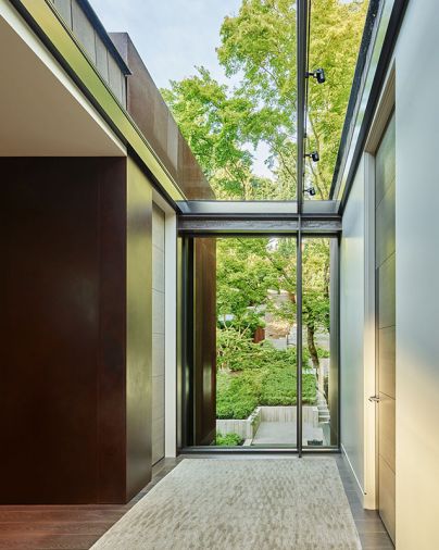 Baba designed the first-floor landing window to overlook entry and sloped property then lit it above from skylight. Cor-Ten steel column left adds rustic texture; Lapchi rug.