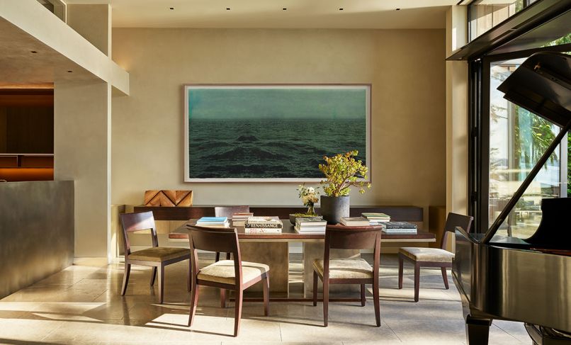 Christian Liaigre dining chairs join Hunziker’s table with nickel-plated steel base and hand-carved dark stained oak top. Limestone Pental Cenia Gray tile floors; Peter Millett sculpture.