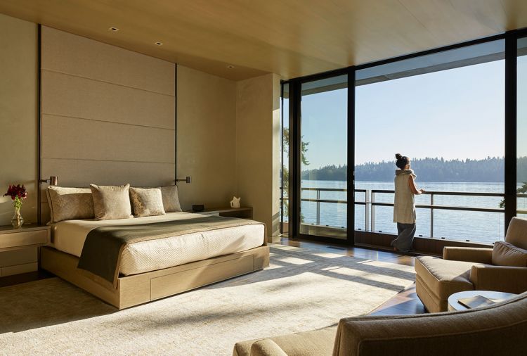 Master bedroom moved from bottom to new top floor for more majestic views. Holly Hunt lamps modified to built-ins; Stusser Woodworks bedside table design echoes Henry Calvin Legacy Linen naturale paneled headboard. TV rises out of bed platform drawer. Custom lounge chairs with S Harris/Grain Twill.