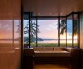 Double Taj Mahal stone master sink looks out over planted flat green roof toward views. Polished Brazilian quartzite wall mirrors view.