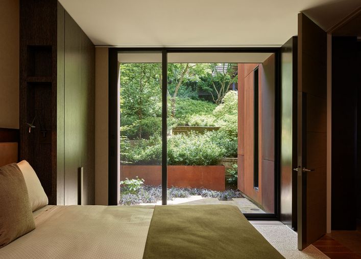 A guest bedroom with custom steel pull cabinetry hardware and Fleetwood sliding door is located off the main public zone that includes formal entry and living/dining areas.