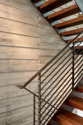 A board form concrete wall adds texture and visual interest to the stairwell.