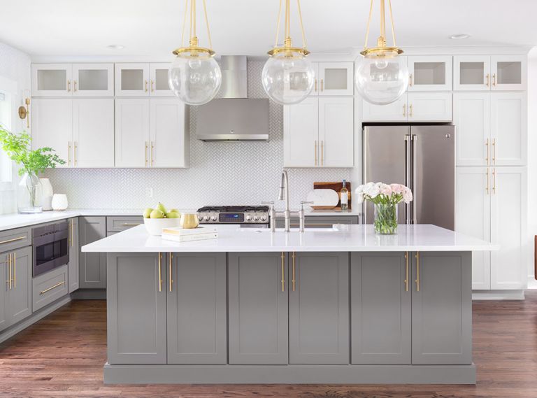 CABINETRY A standout in the mostly white kitchen, the mid-tone gray hue from Benjamin Moore on the cabinets is augmented by the gold in the hardware. COUNTERS + LIGHTING White Space chose Pental Quartz countertops with a subtle, yet warm veining to add interest but keep the kitchen’s clean, uncluttered aesthetic.