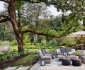 The family’s lush outdoor retreat, including access to Issaquah Creek, a lawn and meadow, and a putting green, was created by landscape architects Land Morphology. On the patio, outdoor furniture from Restoration Hardware is shaded by a Barlow Tyrie umbrella, and hanging chairs from CB2 and poufs from Article are whimsical options.