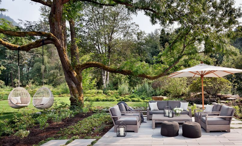 The family’s lush outdoor retreat, including access to Issaquah Creek, a lawn and meadow, and a putting green, was created by landscape architects Land Morphology. On the patio, outdoor furniture from Restoration Hardware is shaded by a Barlow Tyrie umbrella, and hanging chairs from CB2 and poufs from Article are whimsical options.