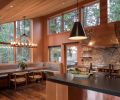 A newly added dining nook in the kitchen offers a less formal area for eating and activities. Designed to be durable, Carolyn Woofer employed Knoll commercial fabric as part of a “refined rustic” look. Pendants over the kitchen island subtly reference cowbells, while copper accents add shimmer against stone.