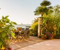 Landscape architect Jason Breitling of Cambium, Inc., who undertook both landscape architecture and landscape construction, creates a romantic dining area in the back garden that cantilevers out over Lake Washington. Two towering propane patio heaters mimic the height of the distant city skyline as well as the graceful Abutilon (“Tiger Eye” – Flowering Maple) right, which Breitling pairs with other perennial tropical plants that thrive in the microclimate formed by the garden’s proximity to the lake, which helps moderate the temperature year-round.