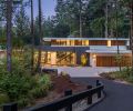 Sited on a 1.2 acre, heavily forested property, this home in the Portland area feels enveloped by the landscape. The exterior blends traditional stucco in two different shades as well as vertical red cedar. Wide overhangs protect the siding while also creating strong horizontal lines in contrast to the vertical cedar. A reflecting pool near the front entrance pulls in light and sets a spa-like tone even before you step inside.