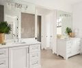 The master bathroom echoes the lovely light feeling in the rest of the house. Hayes Cabinets provided the cabinetry, which pair with white countertops, chrome hardware, and lighting fixtures. A concrete-look porcelain tile on the floor and raised geometric tile accent wall behind the freestanding bath round out the space, while large mirrors reflect the room’s coveted light.