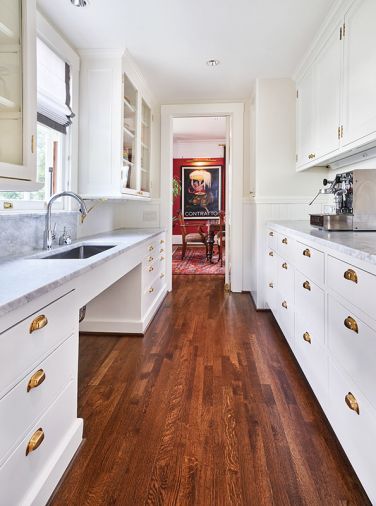 Original butler’s pantry glass cabinetry and cup bin pulls left. Jeff’s hidden VRV HVAC panel design is held up with earth magnets. Currant red dining room walls and oversized poster art seen beyond.