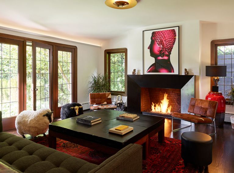 Key architectural elements of this 1927 Tudor style home with French Normandy flourishes remain intact today: voluptuously curved mahogany windows, trim and leaded glass windows restored to their former glory. In the living room, Chadbourne + Doss Architects brought the existing fireplace front and center with a faceted blackened steel surround. Gleaming Blaze lighting by Modern Forms draws the eye to new cove uplighting. Homeowners’ artwork, a Buddha photograph, adds drama to historic architecture.