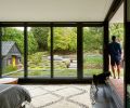 An enlarged master bedroom features Kolbe Vistaluxe windows and sliding doors that open onto the covered porch.