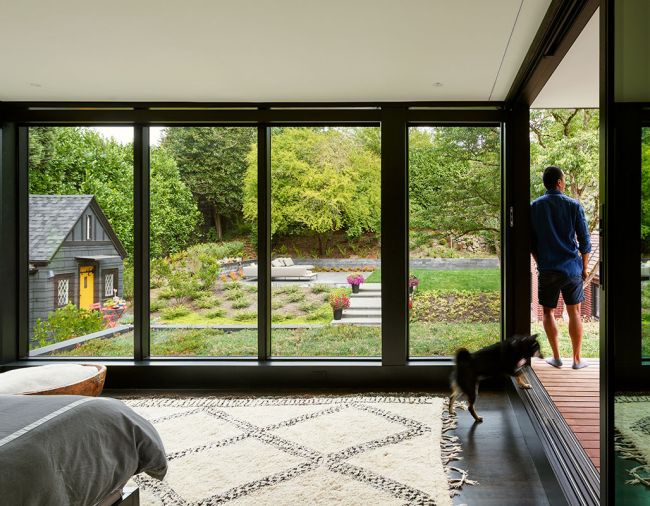 An enlarged master bedroom features Kolbe Vistaluxe windows and sliding doors that open onto the covered porch.