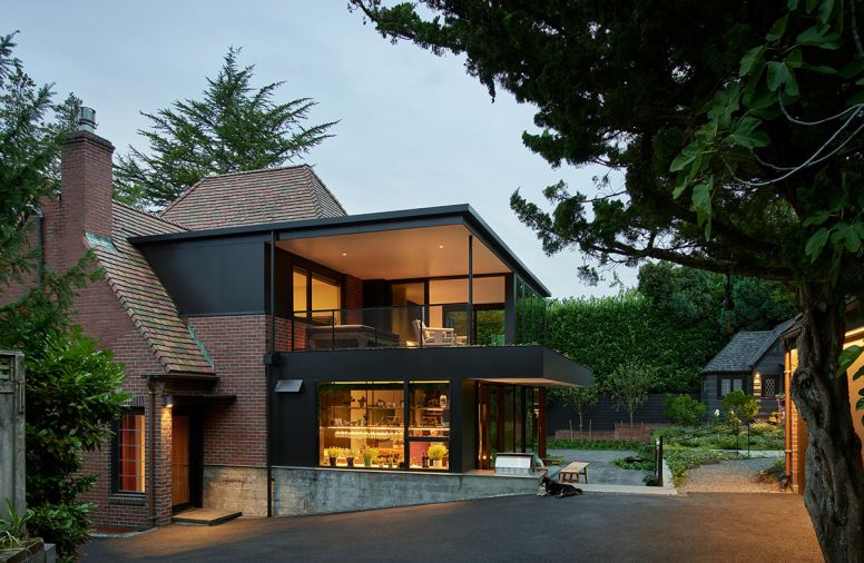 An existing flat roof dormer was expanded to accommodate the new addition. Salvaged demolition brick pairs with black painted Aluminum plate siding to transition from old to new.