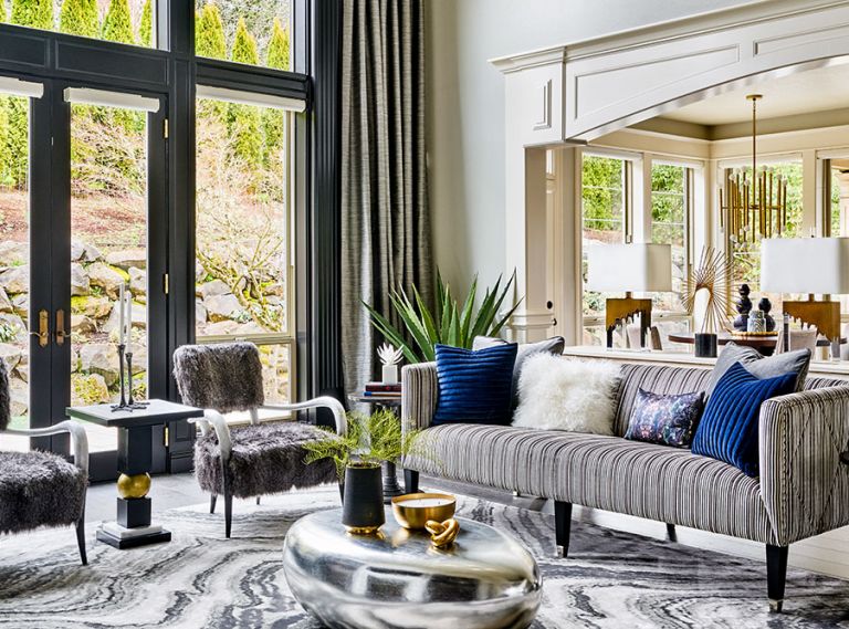 To open up the living areas, heavy traditional elements were eliminated, including quadruple crown moldings, massive Roman columns that blocked passageway from the living area to dining nook. Edgy fur chairs with bone pair with pinstriped velvet sofa.