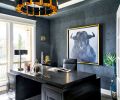 The husband’s office walls heavily textured masculine-feel by Bravura Finishes. Arteriors chandelier echoes brass glow. Bullish thematic artwork by Leftbank; desk by Noir.