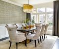 Although no structural changes were made to the dining room, the interior design decisions altered it dramatically: Wallquest Modern Elegance wallpaper that crowns the original classic wainscoting; replacing a traditional wedding cake chandelier with an elegant oval Arteriors chandelier to become the icing on this cake.