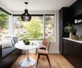 In one portion of the kitchen, designers Alex Childs and Brooke Prince created a dining nook. A built-in bench matches the cabinetry and conceals storage space underneath the cushions. The pedestal table and bentwood dining chairs incorporate touchstones of mid-century modern style.