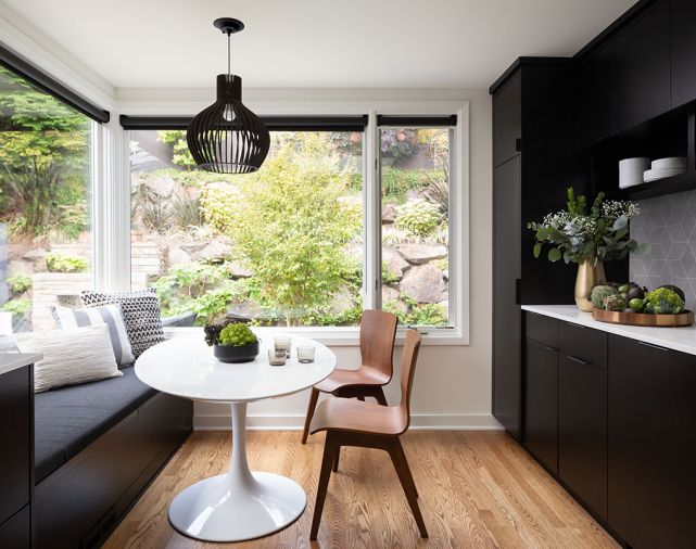 In one portion of the kitchen, designers Alex Childs and Brooke Prince created a dining nook. A built-in bench matches the cabinetry and conceals storage space underneath the cushions. The pedestal table and bentwood dining chairs incorporate touchstones of mid-century modern style.