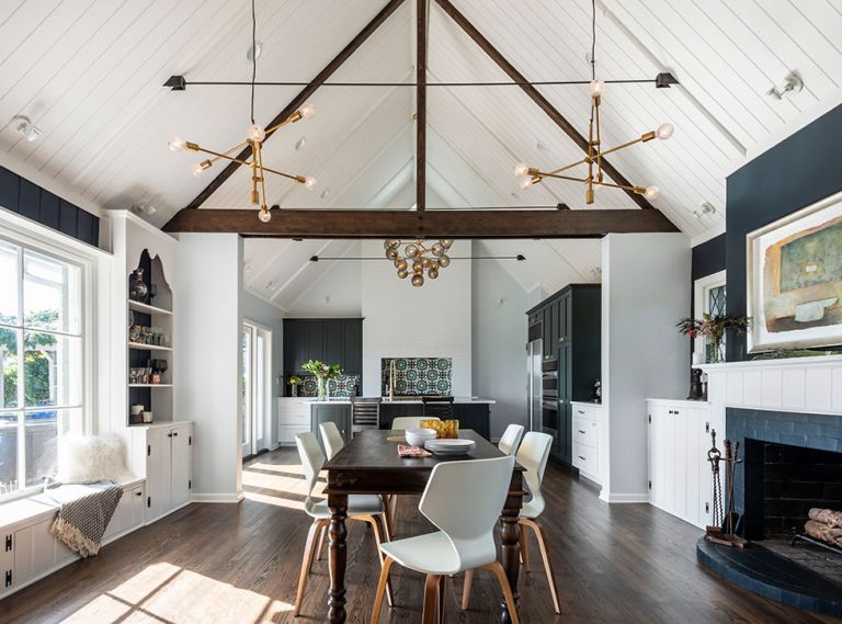 A typical 1940s interior—think lots of small, defined spaces separated by doorways and walls—made the kitchen and dining areas feel cramped. By removing interior walls and raising the ceiling to the roofline, this project transformed a historic home into a light, bright, airy space. Yet by keeping the original built-ins and echoing traditional design elements like crown molding and lapboard in other areas of the home, the remodel stayed true to the underlying structure.