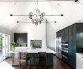 French doors connect the kitchen to the home’s yard and patio, linking the indoor and outdoor spaces and enhancing the open, airy feel created by the high ceilings. Custom cabinets were trimmed out to resemble furniture, then painted in Farrow & Ball Studio Green. The dark color adds a sense of drama to the otherwise light, bright space.  Jeff chose quartz for the countertops for its durability and clean, understated look. The backsplash is custom tile from Cement Tile Shop, laid in a graphic geometric pattern.