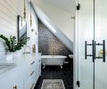 The wallpapered wall behind the tub in the master bathroom hides a hidden door leading to more storage. “Sometimes a really intricate pattern can help conceal things,” says Jeff.