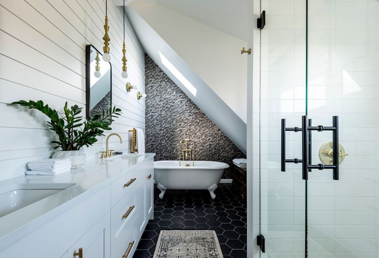 The wallpapered wall behind the tub in the master bathroom hides a hidden door leading to more storage. “Sometimes a really intricate pattern can help conceal things,” says Jeff.