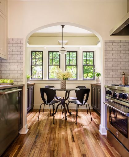 There were two elements of the 1925 cottage kitchen that Chelly knew she would maintain: the arched entry into the breakfast nook and the original windows and glass. Adding display shelves with corbel brackets increased storage space, as did the construction of new cabinetry painted Benjamin Moore Wrought Iron like the kitchen cabinets. Mixing modern with period correct furnishings inspired the combo of comfy Design Within Reach Globus chairs paired with a traditional wrought iron legged table from Rejuvenation.