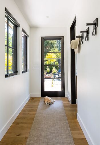 Metal clad Loewen windows have wooden interiors, painted black. Portella door opens to back patio, Paloform Bol adds pop of color and contrast. Golden locust tree adds halo of gold to Treherne’s landscape design