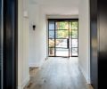 Looking from kitchen toward Portella steel and glass entry door with flanking side lights. Garage visible beyond.