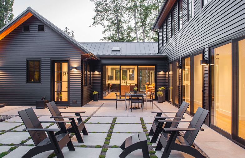 Back patio trimmed in Herniaria glabra toward kitchen. Tongue and groove cedar trim on eaves adds interest to dark siding and metal clad Loewen windows.